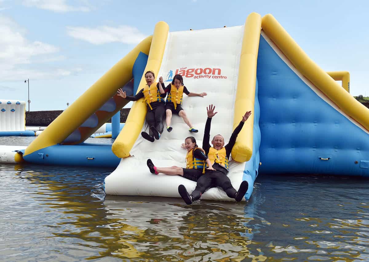 A family going down the large slide in the inflatable Water Park in Ireland