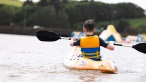 Boy kayaking wearing life jacket supplied by The Lagoon