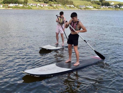 Two people using stand-up paddleboarding in Cork