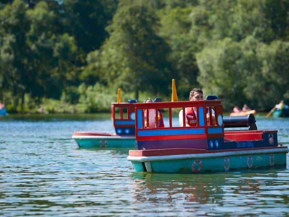 Family on a Mini Captain water ride smiling as they navigate the shallow waters of the lagoon surrounded by gentle waves.